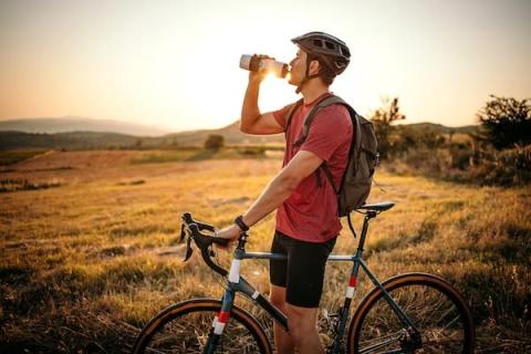 Man taking a water break from mountain biking