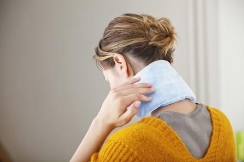 Woman holding ice pack on her neck